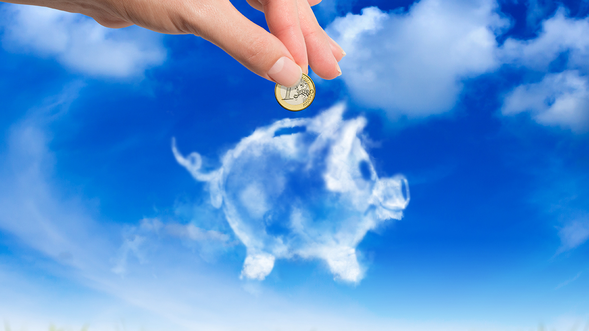blue sky with cloud shaped as a piggy bank and a woman's hand is putting a coin into it